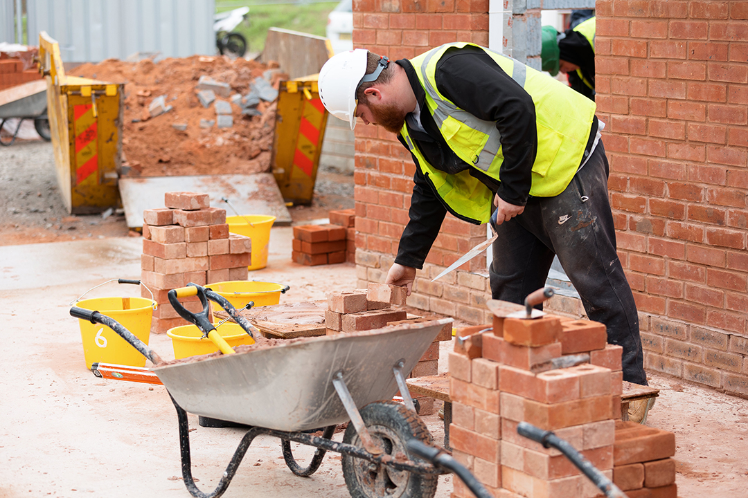 a photo of some bricklayers at work wearing site safety clothing