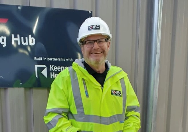 a photo of a man in site safety clothing smiling joyfully at the camera