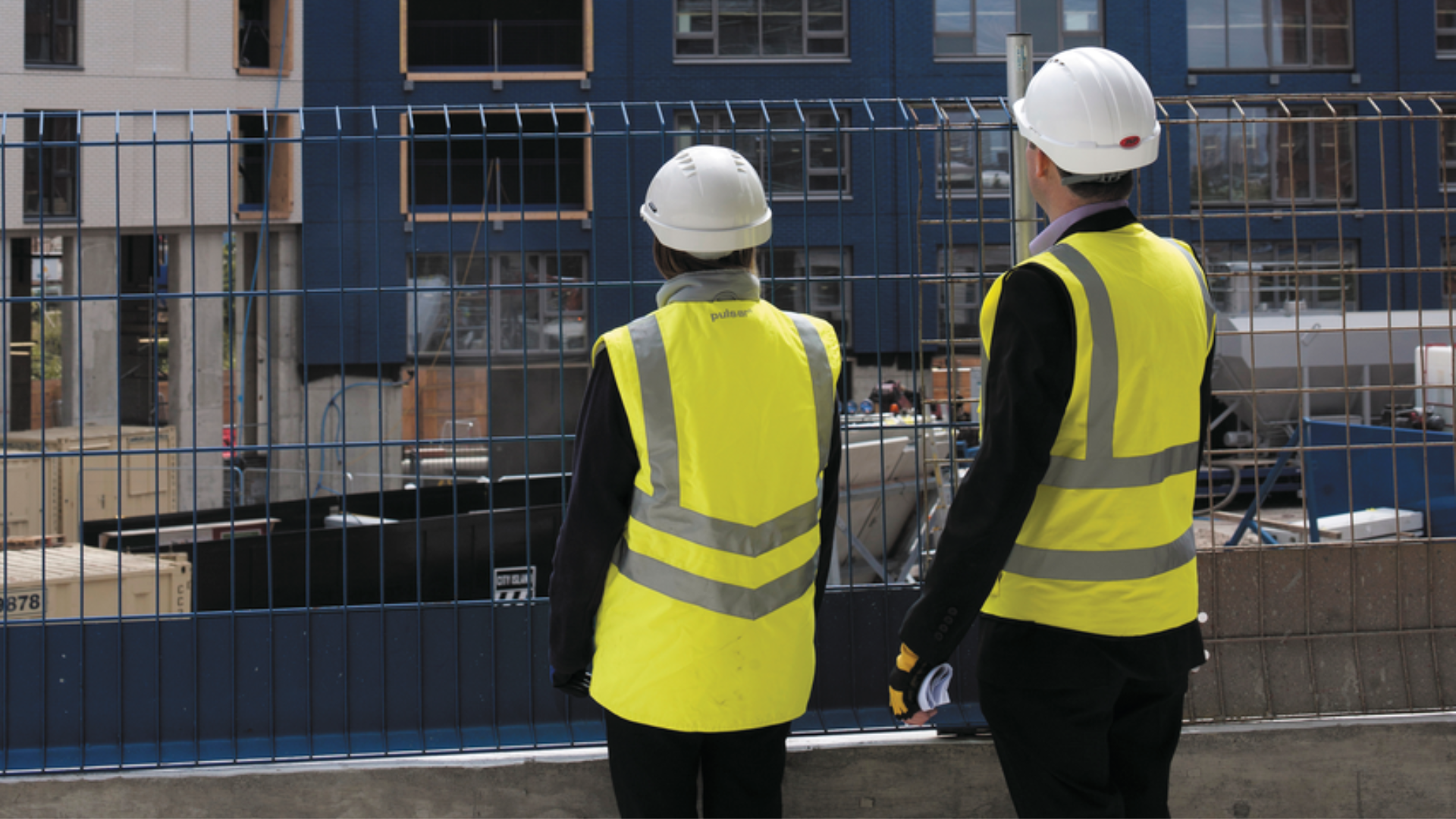 a photo of two people on site wearing site safety clothing