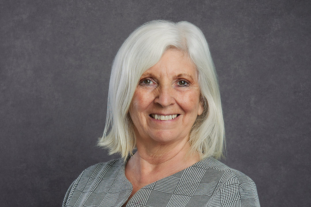 Dr Teresa Robson-Capps, Non-executive Director of the Board of NHBC, smiling at the camera on a grey background