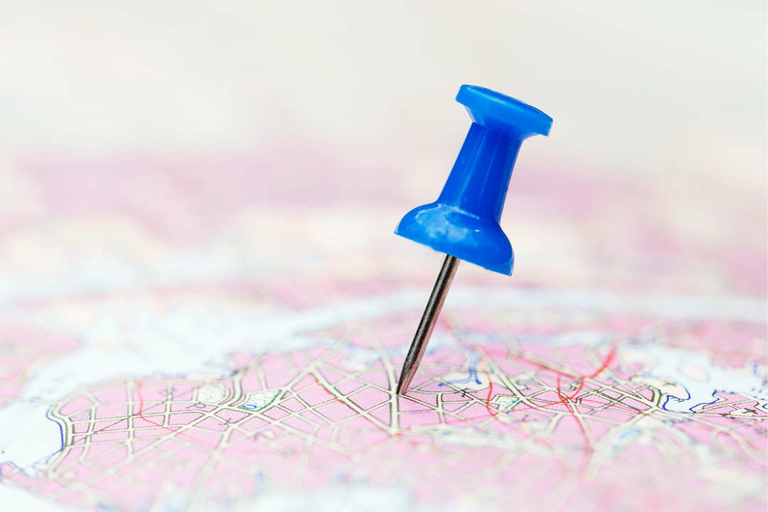 a blue pin stuck into a light magenta map