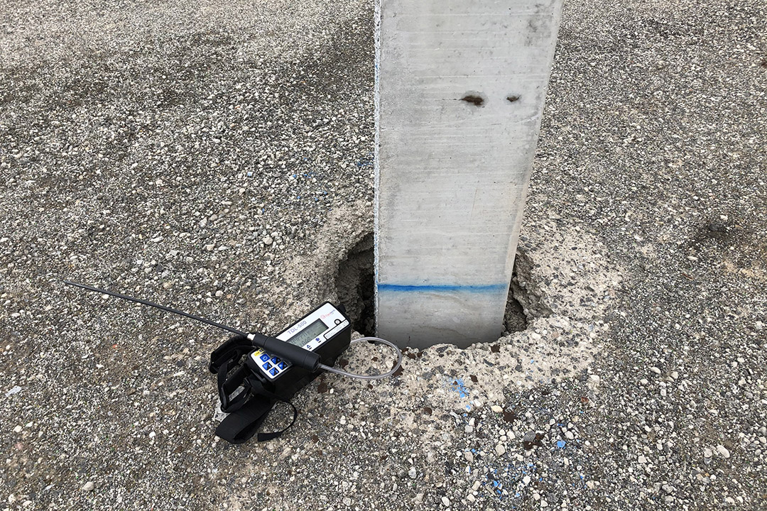 a photo of a gas meter next to a pole