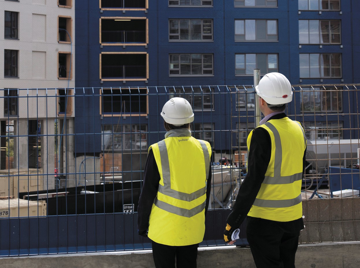 two people talking on site in site safety clothing