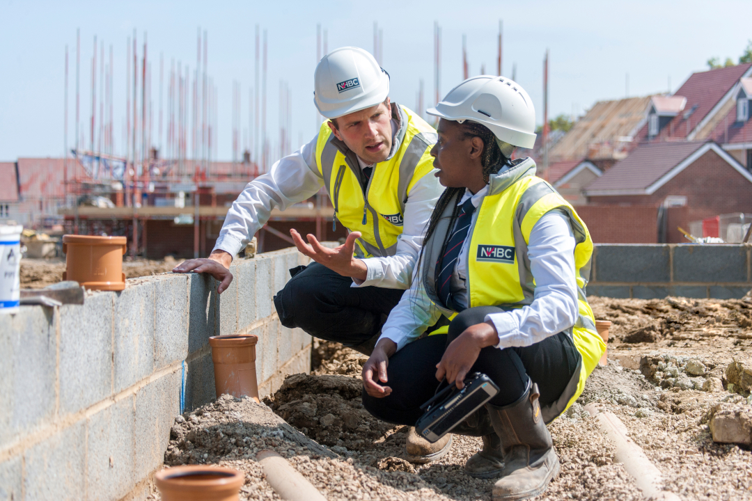 a photo of two people sitting on site while wearing site safety clothing