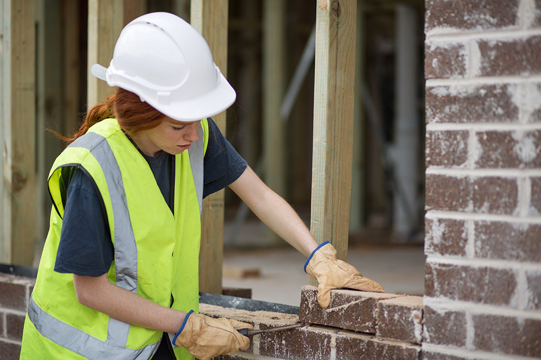 a photo of someone in site safety clothing completing some brickwork