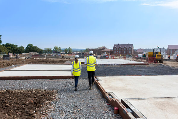 a photo of two people on site having a conversation in site safety clothing