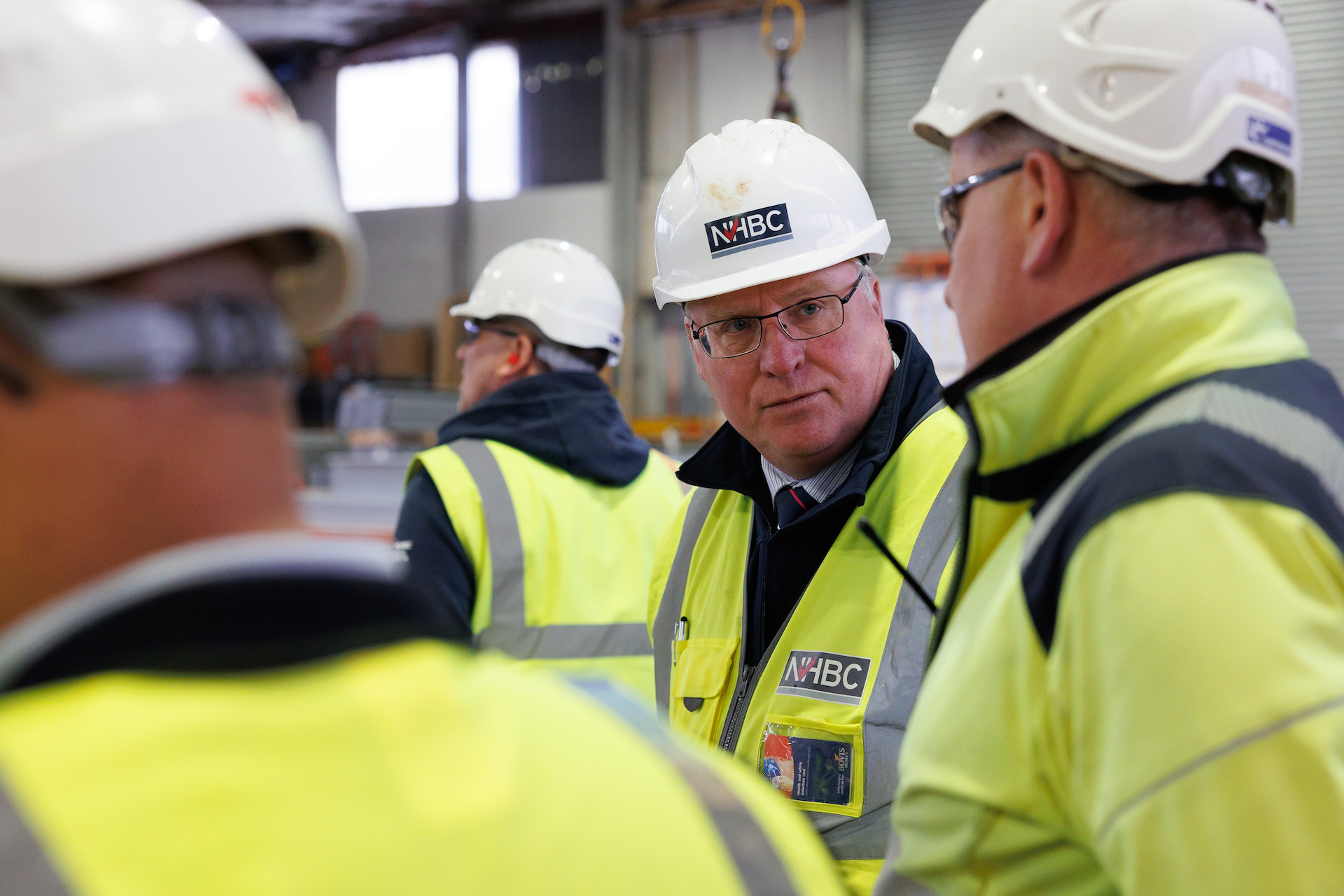 a photo of three people talking in site safety clothing