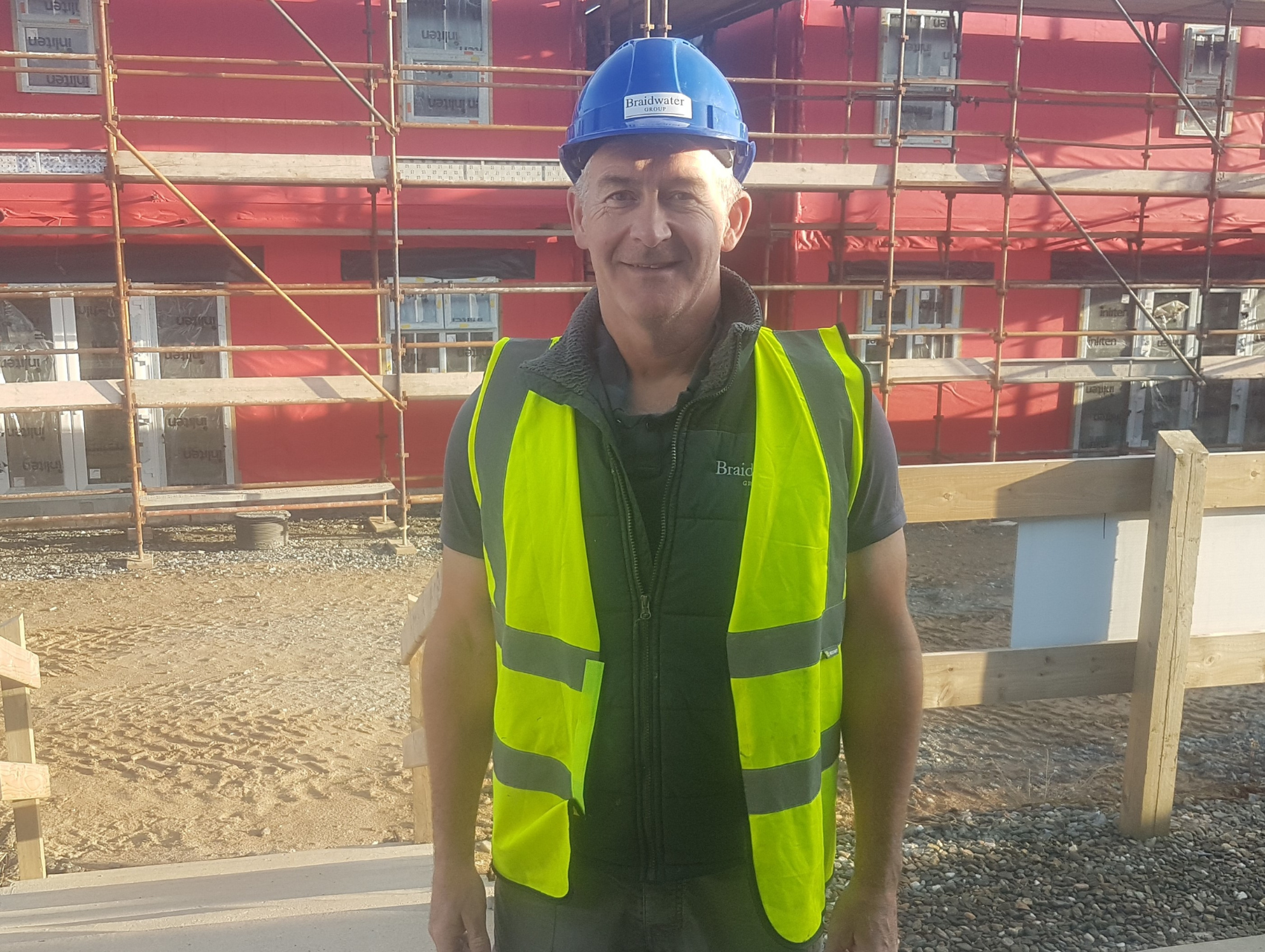 a photo of a man in site safety clothing smiling at the camera