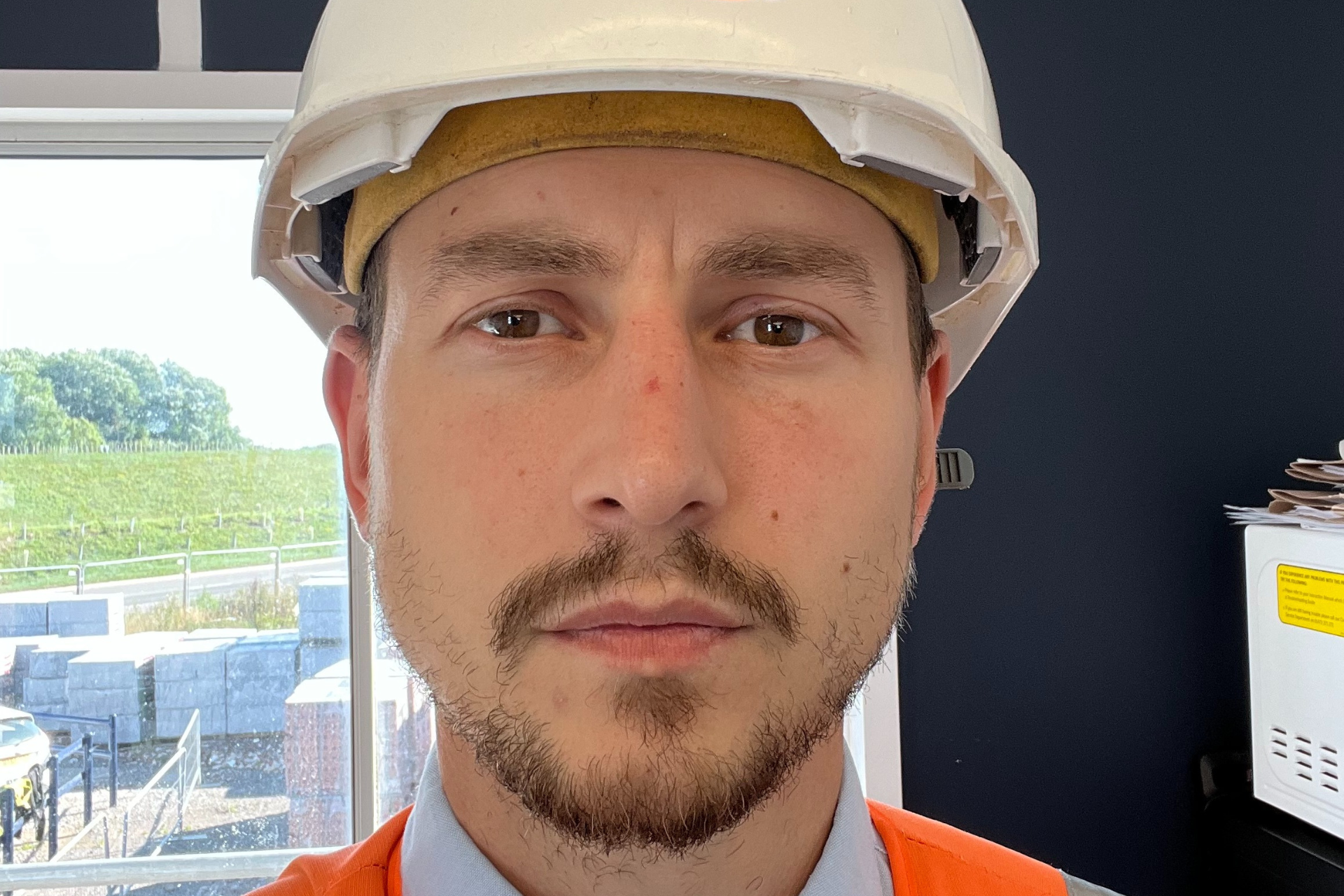 a man in a hard hat with a mustache looking at the camera