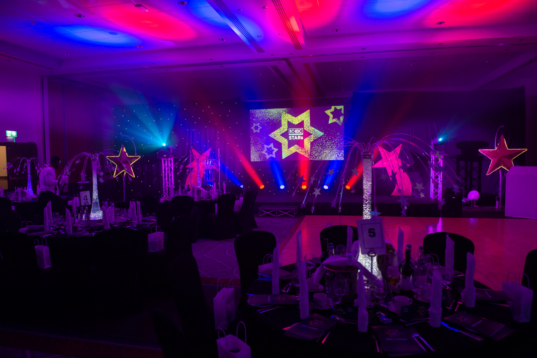 photo taken at the nhbc stars awards, with purple and pink lighting and star accents around the room