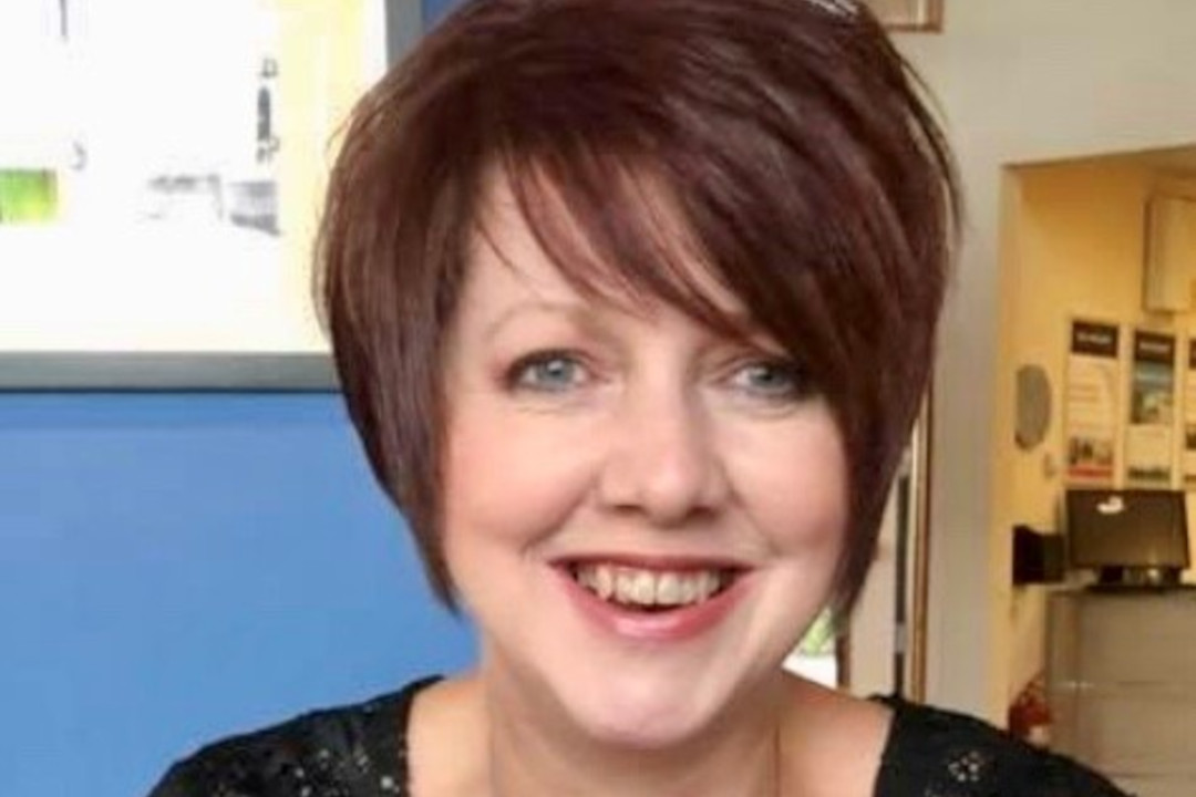 a woman with short brown hair smiles at the camera