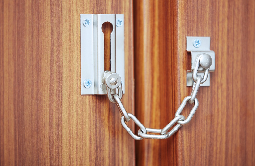 a silver chain lock on a wooden door