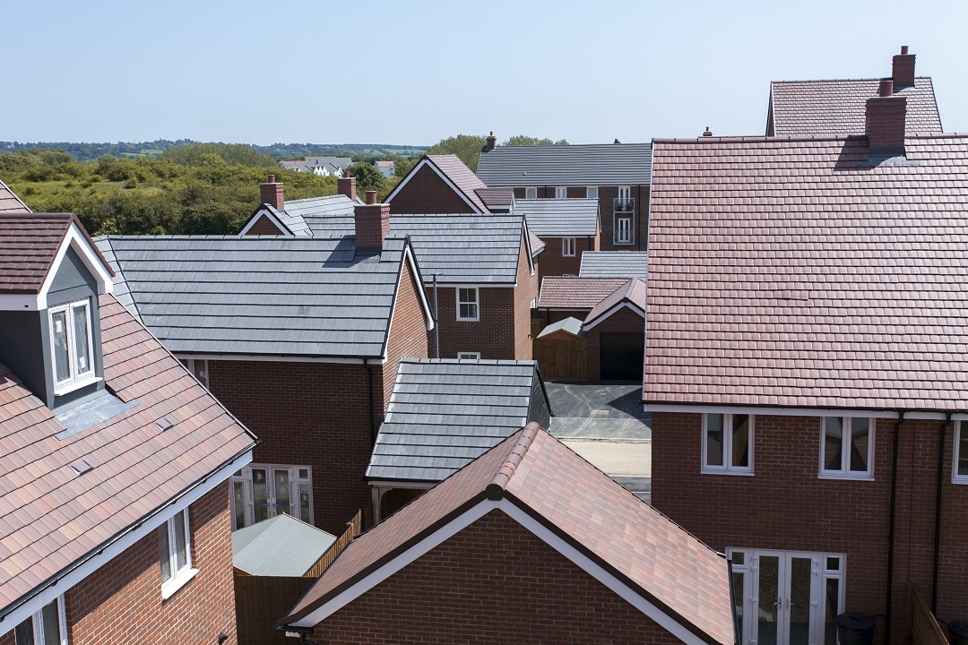 a plt of new build homes with red and grey roofs
