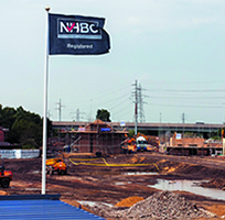 a navy nhbc flag flying high over the start of a building site