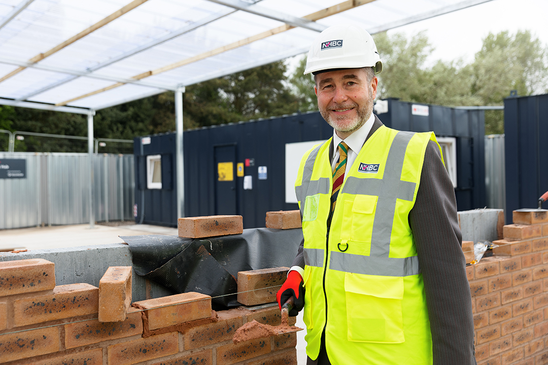 person with high-vis jacket and hardhat smiling at camera