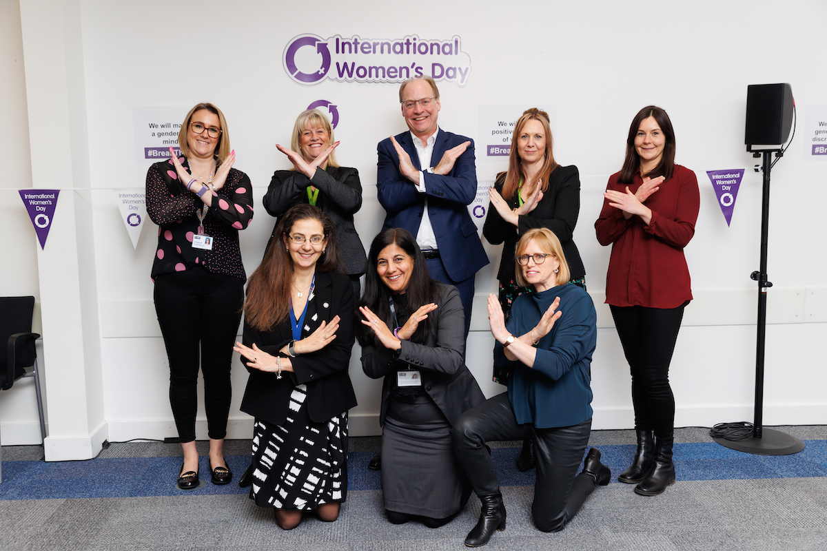 a group of people making shapes with their arms o celebrate international women's day